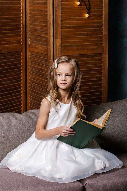 Heureux enfant ouvrant le livre de Noël. Concept de vacances de Noël