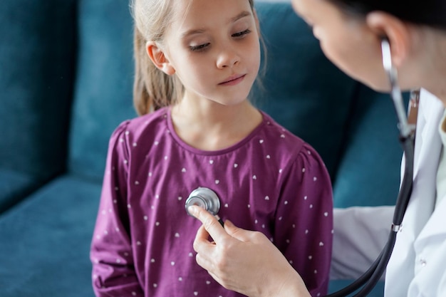 Heureux enfant patient souriant à l'inspection médicale habituelle. Médecin et enfant patient à la maison. Médecine, concepts de soins de santé.