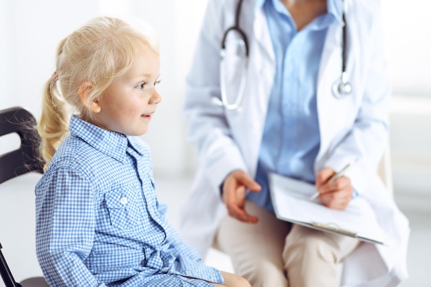 Heureux enfant patient souriant à l'inspection médicale habituelle. Médecin et patient en clinique. Médecine, concepts de soins de santé.