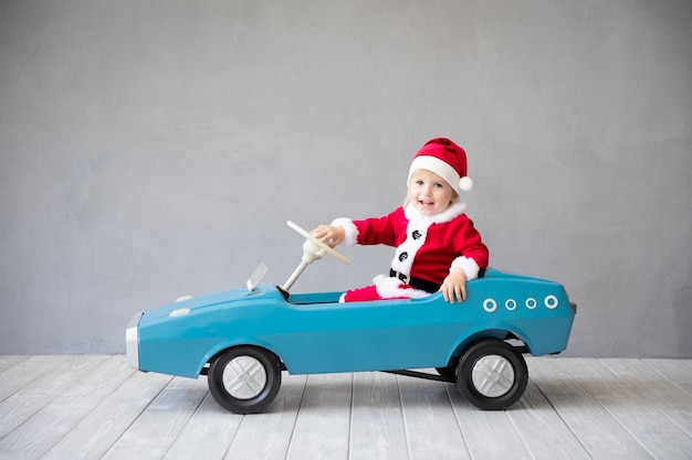 Heureux enfant payant à la maison. Enfant s'amusant le temps de Noël. Concept de vacances de Noël