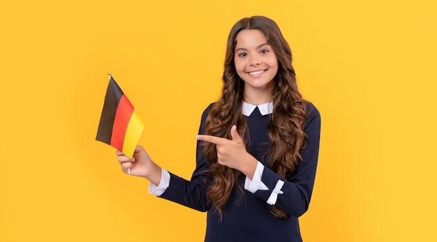 Heureux enfant pointant le doigt sur le drapeau allemand fond jaune zone euro