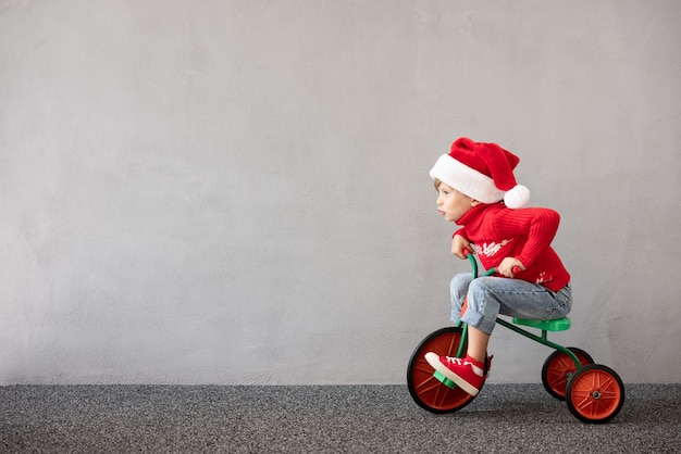 Heureux enfant portant un costume de Noël Kid riding bike