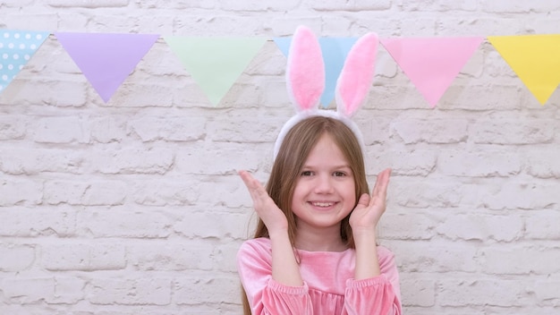 Heureux enfant portant des oreilles de lapin jouant au jeu le jour de Pâques Jolie petite fille s'amusant