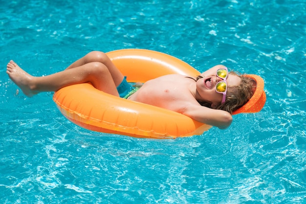 Heureux enfant profitant des vacances d'été à l'extérieur dans l'eau de la piscine