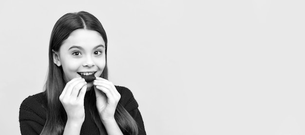 Heureux enfant profiter de manger une délicieuse collation au chocolat fond jaune délicieux affiche horizontale de l'espace de copie d'en-tête de bannière de visage d'enfant isolé