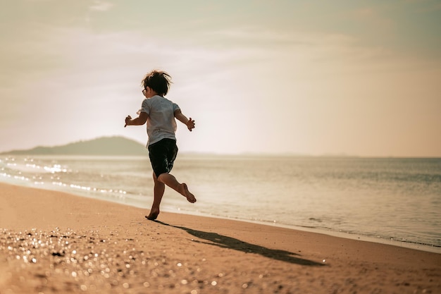 Heureux enfant s'amusant en vacances d'été sur la plage Concept de voyage et de vacances