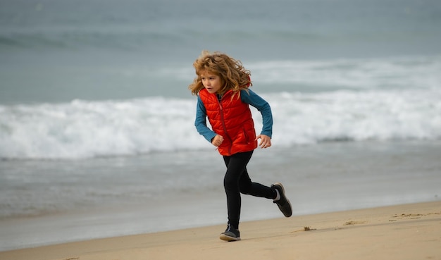 Heureux enfant s'exécutant sur mer plage garçon drôle courir le long du bord de surf enfants actifs mode de vie matin courir w