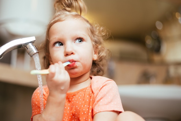 Heureux enfant se brosser les dents le matin dans le bain