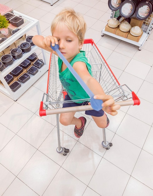 Heureux enfant souriant assis dans un chariot s'amusant