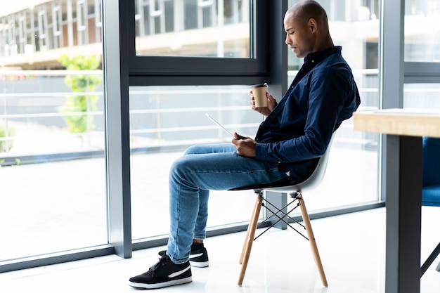 Heureux entrepreneur afro-américain à l'aide d'une tablette tactile.