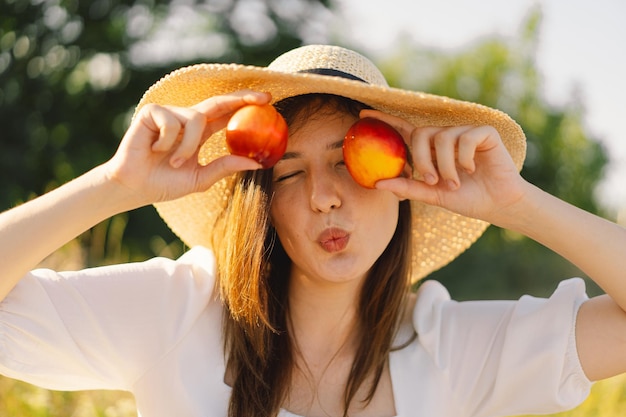 Heureux été insouciant fille dans un champ extérieur avec des fruits de pêche orange