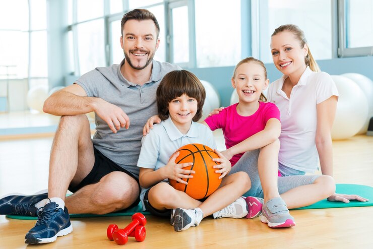 Photo heureux d'être une famille. bonne famille sportive se liant les uns aux autres tout en étant assis sur un tapis d'exercice ensemble