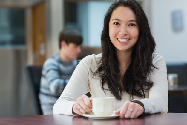 Heureux étudiant assis dans un café