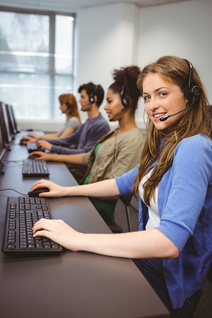 Photo heureux étudiant en classe d'informatique, souriant à la caméra