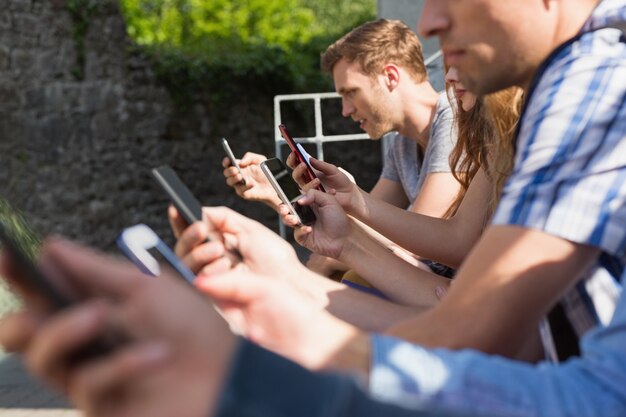 Heureux étudiants assis dans une ligne de textos