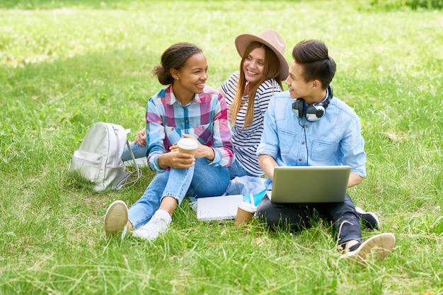 Heureux étudiants profitant d'une pause sur la pelouse