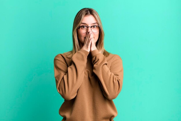 Heureux et excité surpris et étonné couvrant la bouche avec les mains riant avec une expression mignonne