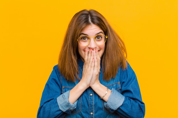 heureux et excité, surpris et étonné couvrant la bouche avec les mains, riant avec une expression mignonne