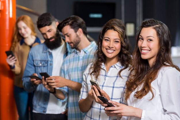 Heureux exécutif mâle et femelle à l'aide de téléphone portable au bureau