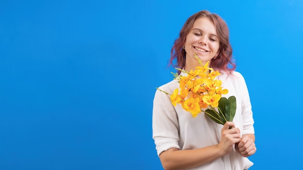 Heureux femme caucasienne souriante avec des fleurs