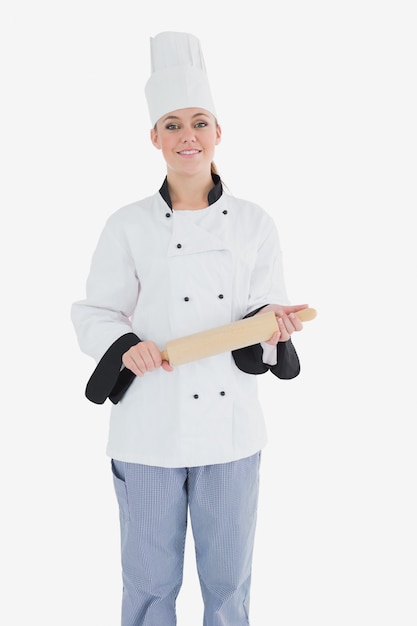 Heureux femme chef tenant un rouleau à pâtisserie