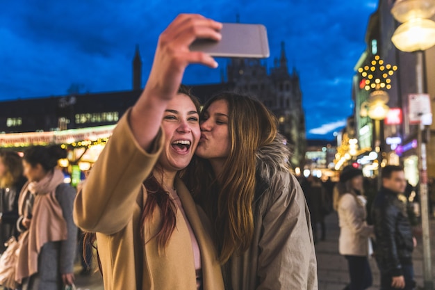 Heureux filles prenant un selfie ensemble au marché de Noël de Munich