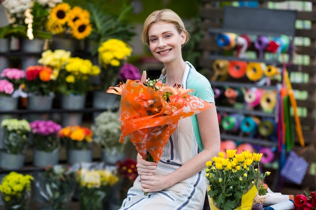 Heureux fleuriste femme tenant un bouquet de fleurs