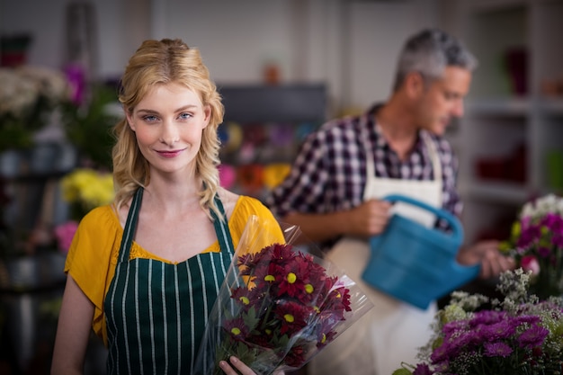 Heureux fleuriste femme tenant un bouquet de fleurs