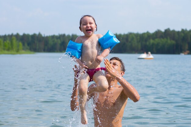 Heureux frère et soeur à la mer s'amuser et éclabousser de l'eau en été