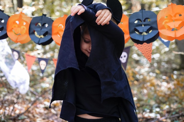 heureux garçon enfant en costume d'halloween s'amusant dans les décorations d'halloween en plein air