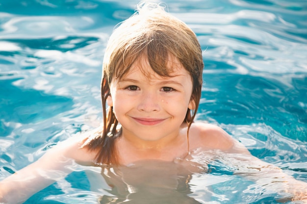 Heureux garçon jouant et dans la piscine ou l'eau de mer visage d'été drôle d'enfants