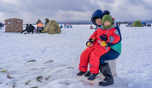 Heureux garçon avec maman sur la banquise de la mer Loisirs Pêche d'hiver