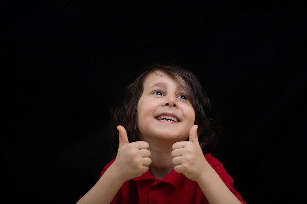 Heureux garçon montrant les pouces vers le haut Bonheur enfant montrant signe ok