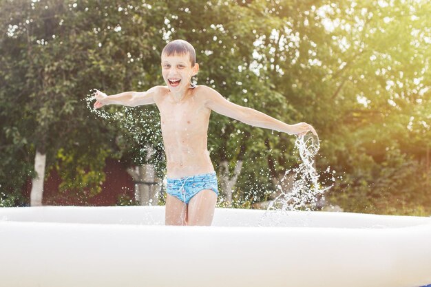 Heureux garçon s'amusant dans la piscine avec son père dans le jardin en été