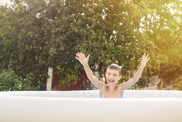 Heureux garçon s'amusant dans la piscine avec son père dans le jardin en été