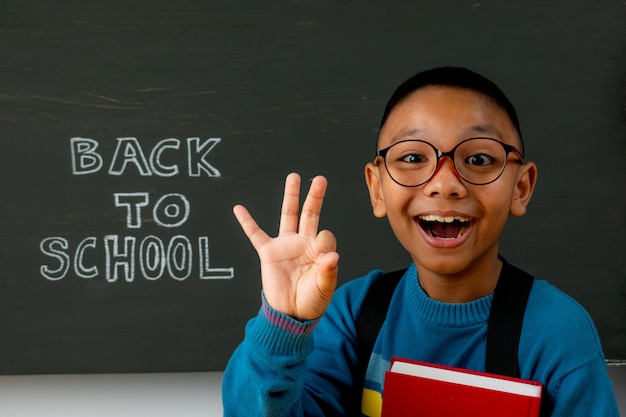 Heureux garçon souriant va à l'école pour la première fois