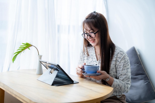 Photo heureux des gens indépendants asiatiques femmes d'affaires tiennent une tasse de café travail occasionnel