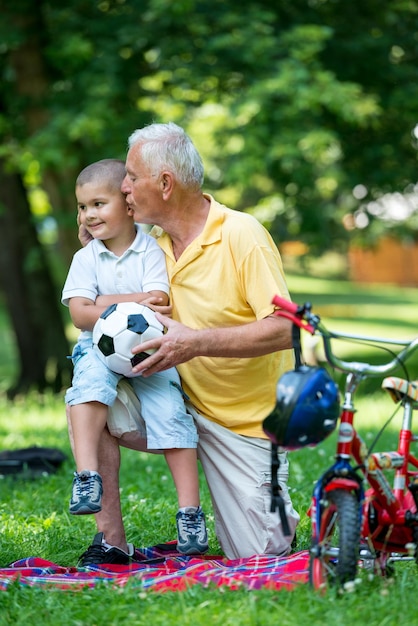 heureux grand-père et enfant s'amusent et jouent dans le parc par une belle journée ensoleillée