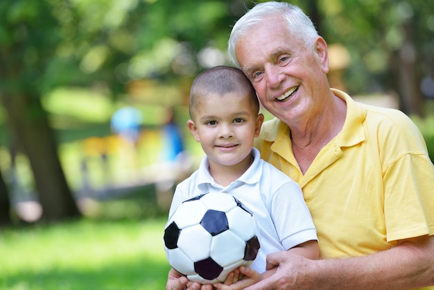 heureux grand-père et enfant s'amusent et jouent dans le parc