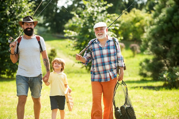 Heureux grand-père père et petit-fils avec des cannes à pêche pêcheurs à la ligne hommes pêche à la journée