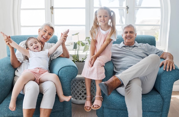 Heureux grands-parents enfants et sourire pour se détendre pendant le temps passé en famille dans le salon à la maison Portrait de grand-mère grand-père et de petites filles souriant dans un bonheur ludique pour le temps libre