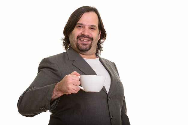 Heureux gros homme d'affaires caucasien souriant et tenant une tasse de café isolé sur blanc