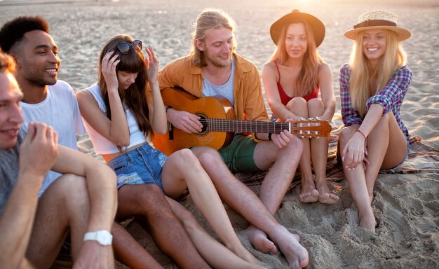 Heureux groupe d'amis ayant une fête sur la plage