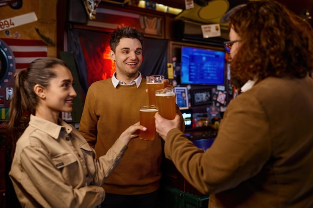 Heureux groupe d'amis divers faisant du pain grillé avec de la bière