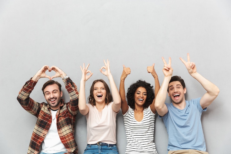 Photo heureux groupe d'amis faisant des gestes avec les mains.