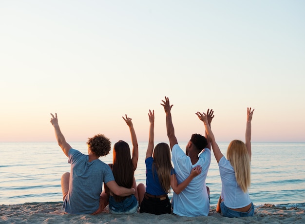 Heureux groupe d'amis levant les mains vers le ciel