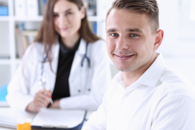 Heureux heureux beau patient de sexe masculin souriant avec médecin