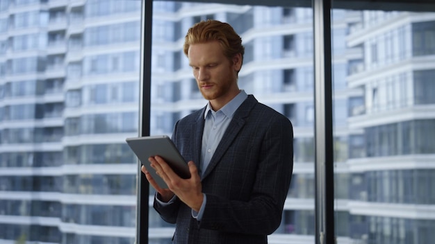 Heureux homme d'affaires à l'aide de tablette numérique au bureau Portrait excité professionnel lisant de bonnes nouvelles sur tablette Homme d'affaires prospère célébrant la victoire