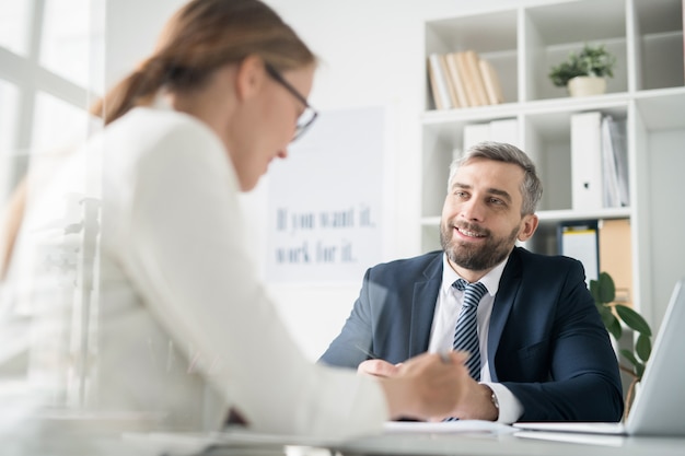 Heureux homme d'affaires discutant des problèmes de travail avec un collègue