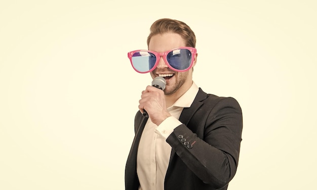 Photo heureux homme d'affaires drôle dans des verres de fête chanter une chanson au microphone karaoké